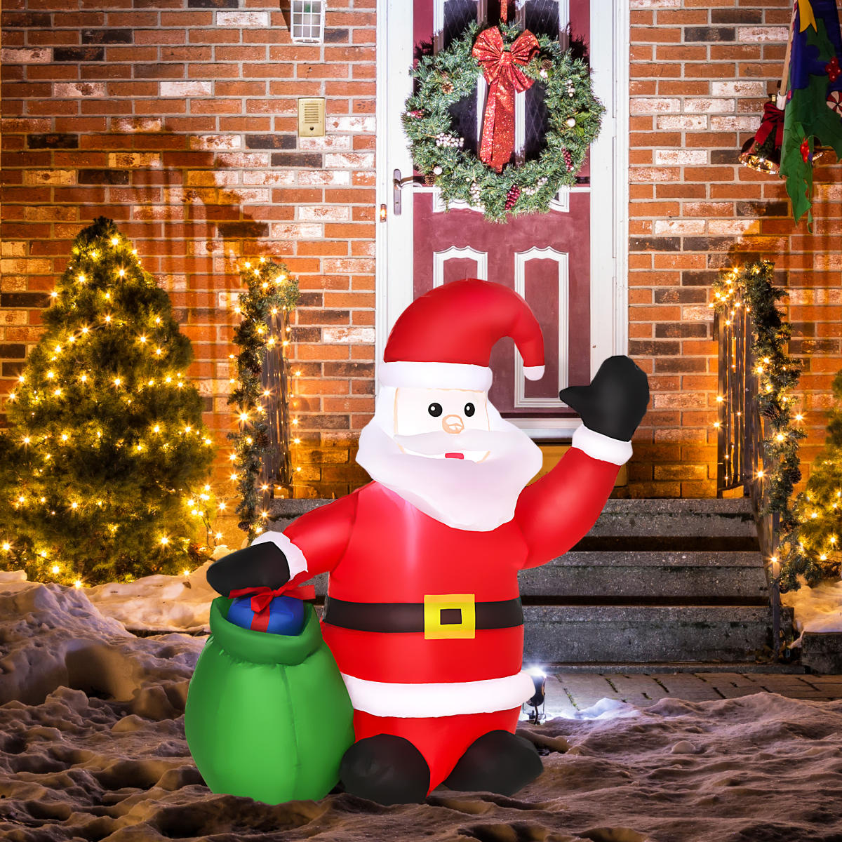 Inflatable Santa Claus figure in front of a brick house with Christmas decorations.