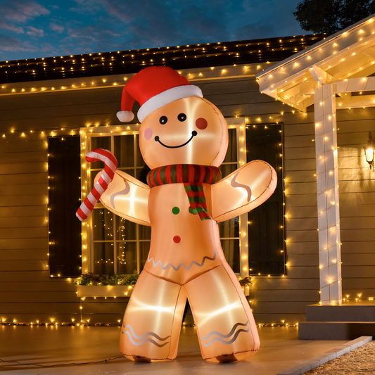 Inflatable gingerbread man decoration with a candy cane in front of a house with Christmas lights.